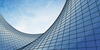 A curving blue glass building against the sky